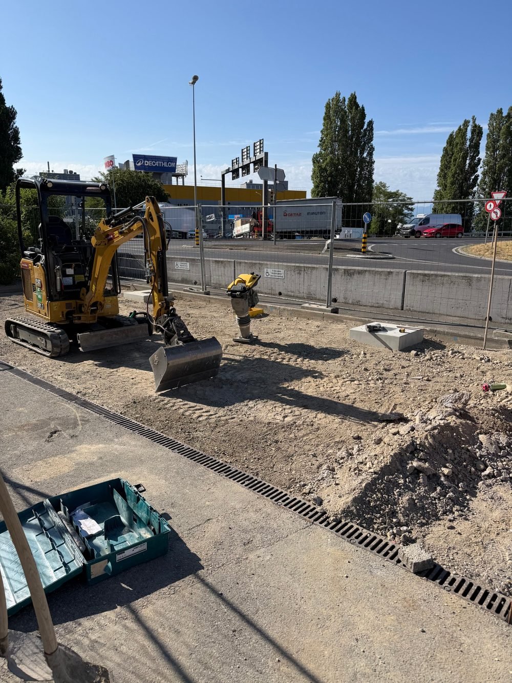 Mini-pelle et compacteur sur le chantier